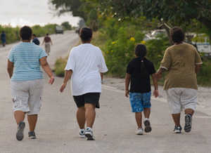Four people walking down a road, for exercise