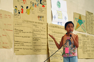Young girl with microphone talking about posters on wall