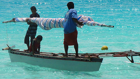 A man and two boys on a small fishing boat