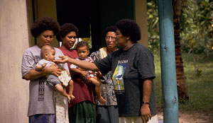 Photo of 4 lady and 2 children in front of a house.