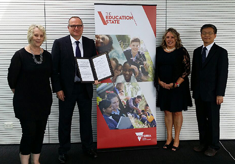 Four people standing next to a banner entitled The Education State (Victoria)