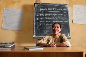 A woman laughs while sitting behind her desk