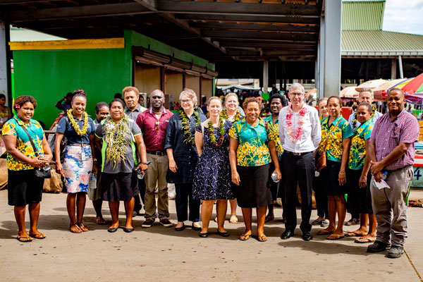 Group photo of Ewen McDonald with market vendors at Honiara Central Market.