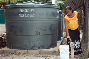 Image of a lady in front of a few water tanks