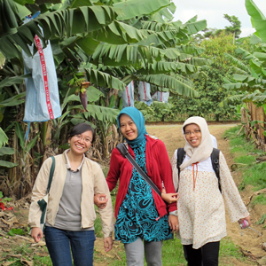 Girls walking,  smiling on a dirt track.