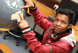 Australia Awards Recipient, Modesto Lopez from East Timor pointing at Australia on a globe of the world