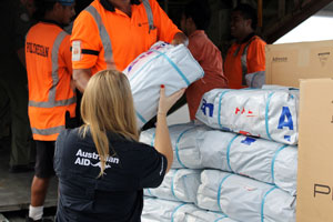 AusAID Rapid Response Team member Sara Dix unloads emergency relief supplies from an Australian C-130 Hercules