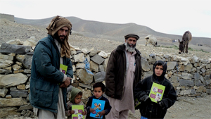 Men and children in Afghanistan with mine risk education materials
