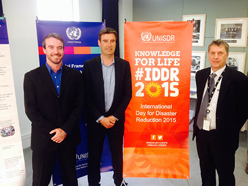 standing in front of an IDDR banner