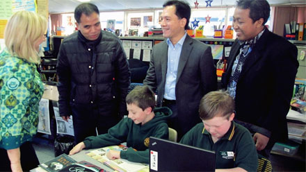 Rikard Bagun, Arief Suditomo and Abdul Rokhim chat with BRIDGE teacher Kathy McVeigh and students.