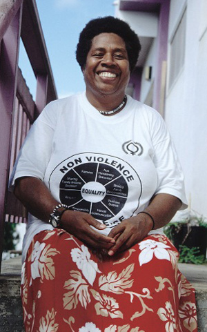 Woman smiling, with non violence written on her t-shirt
