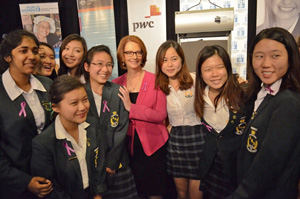 Prime Minister Gillard with group of girls in school uniform, all smiling