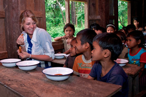 Jessica sharing a meal with Laos children