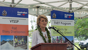 Foreign Minister Julie Bishop standing and talking in front of Australian aid signs