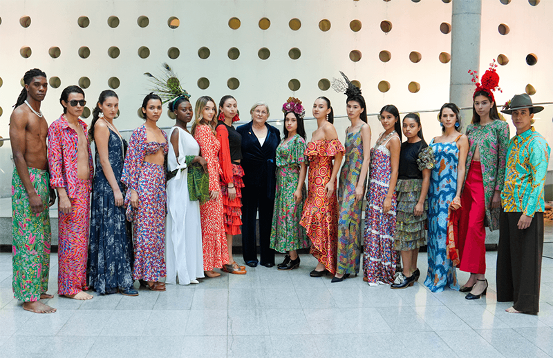 A large group of women in bright clothing, standing in a line