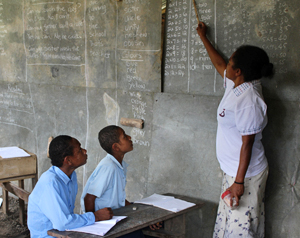Two students looking at a teacher in a PNG classroom.