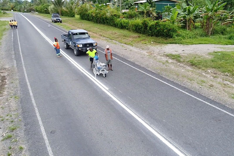 Aerial photo of local contractors painting white lines on a road.