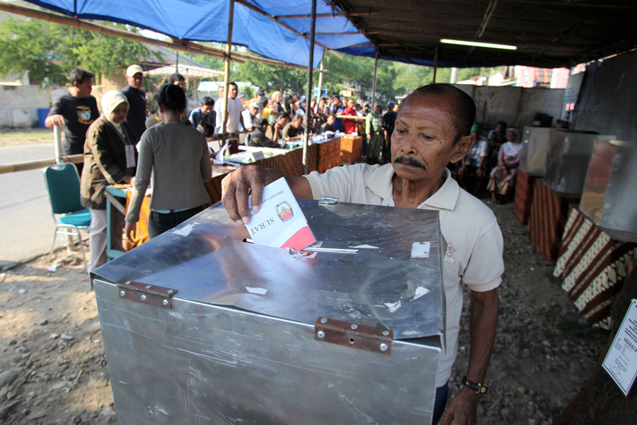 Man pulling his vote ina ballot box