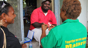 Two women give a man a medical test