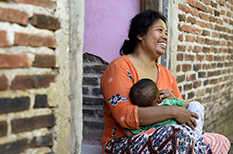 A woman sitting with baby in her arms