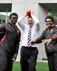 Photo of Parliamentary Secretary for the Pacific Island Affairs Richard Marles with two rugby players