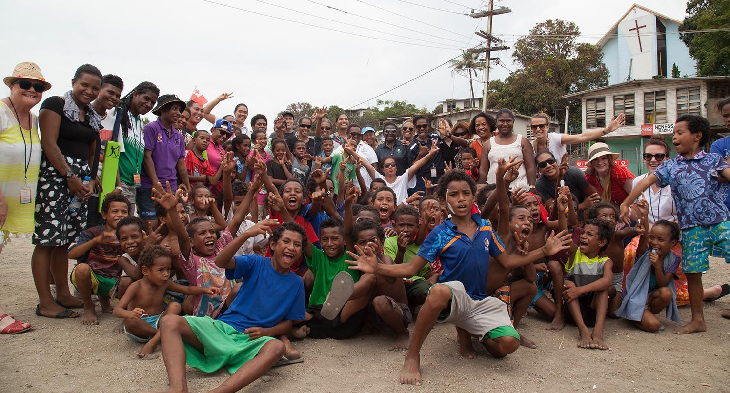 Jane Livesey standing with a large, cheering group of mostly children