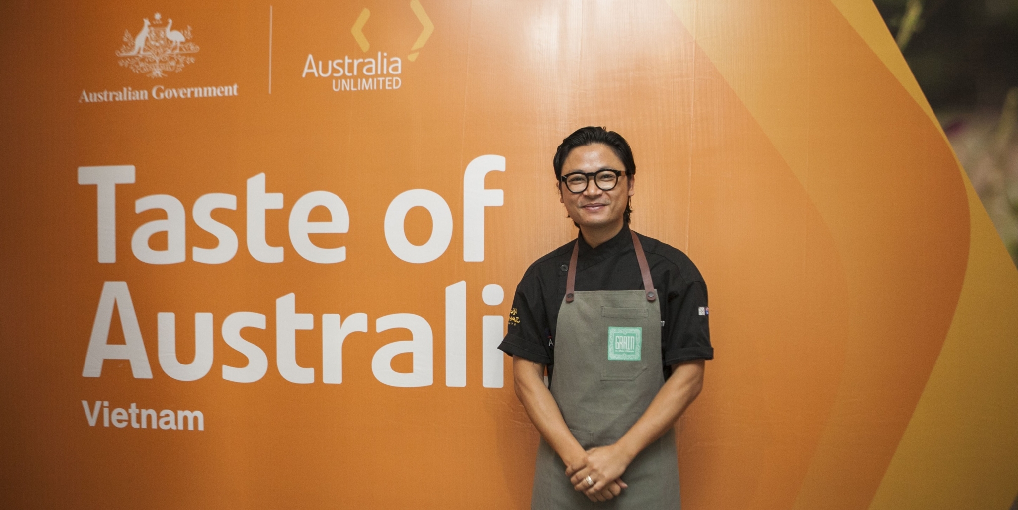 Luke Nguyen in front of an orange Taste of Australia, Vietnam banner