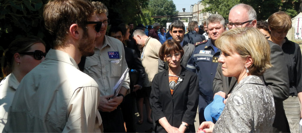 Nigel Stanier standing in a group with Foreign Minister Julie Bishop and others, looking serious