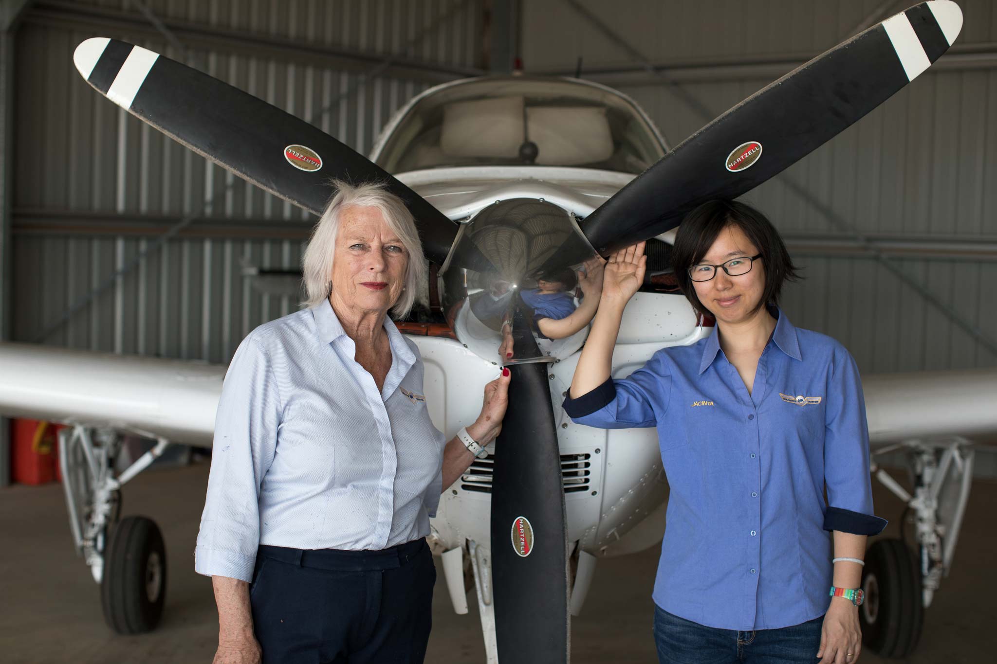Wendy Mann standing at the front of a light aircraft with a colleague