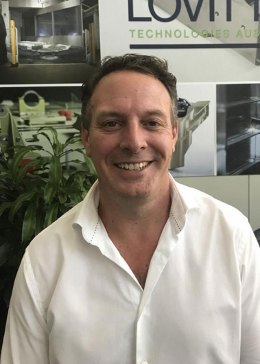 Marcus Ramsay headshot in front of office wall