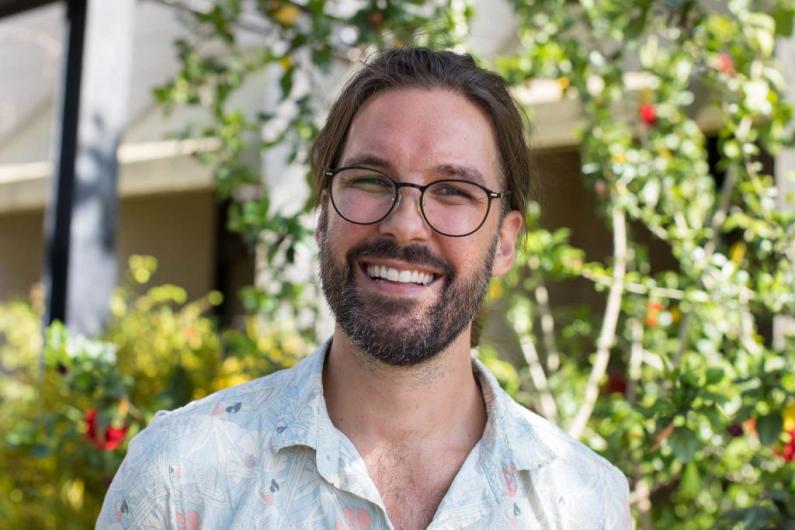 Matthew Grigg headshot, leafy green backdrop
