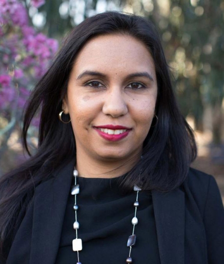 Sheena Graham, headshot, trees and pink blossom in background