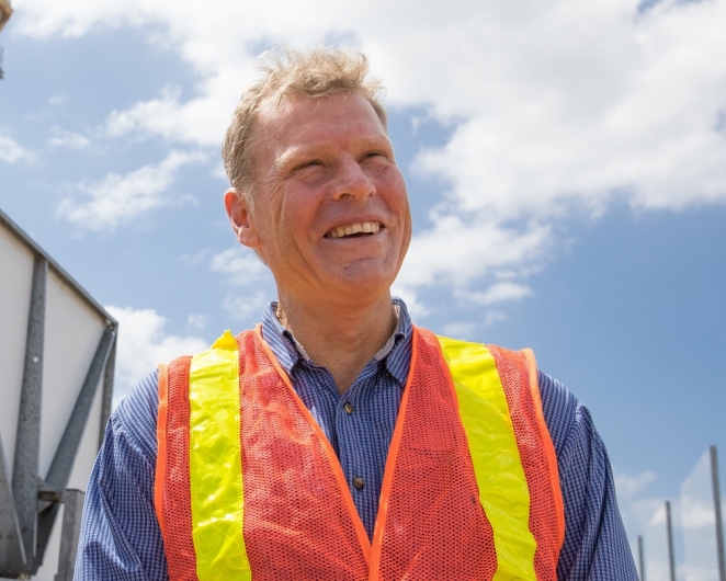 Wes Stein, in fluro vest, standing among a field of solar thermal panels