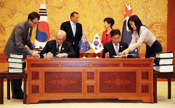 Trade Policy Officer, Lachlan Scully (left), supports Minister for Trade and Investment, Andrew Robb AO, and ROK Minister for Trade, Industry and Energy, Mr Yoon Sang-jick, signing KAFTA, watched by Prime Minister Tony Abbott and ROK President Park Geun-hye, Seoul, 8 April 2014