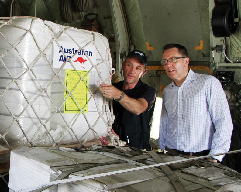 Emergency Manager, Ray Bojczuk (left), briefs Parliamentary Secretary Brett Mason on the emergency stock, part of Australia’s response to the Solomon Islands flooding, Honiara, 11 April 2014. [DFAT]
