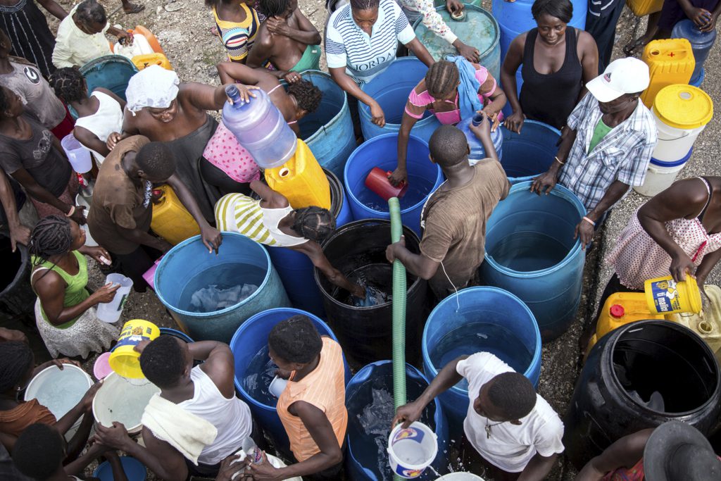 A tanker truck provides chlorine-treated spring water to people displaced by Hurricane Matthew, Haiti. [UNICEF/Roger LeMoyne]