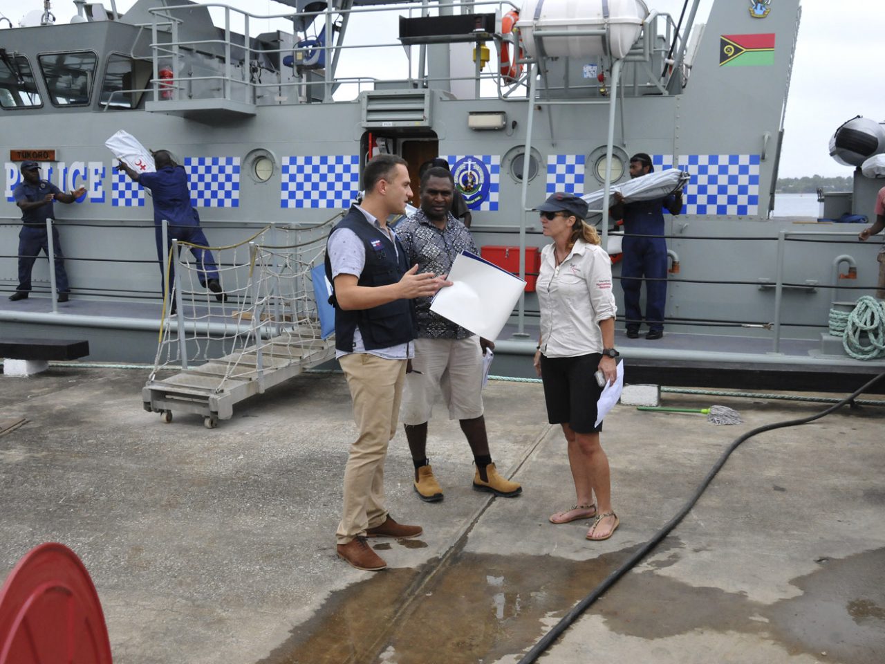 Australian Civilian Corps Specialist Ben Millington with Jimmy Naura (Vanuatu National Disaster Management Office) and Trish Thornhill (RedR) in front of Vanuatu’s patrol boat RVS Tukoro. [DFAT/Patrick Haines]