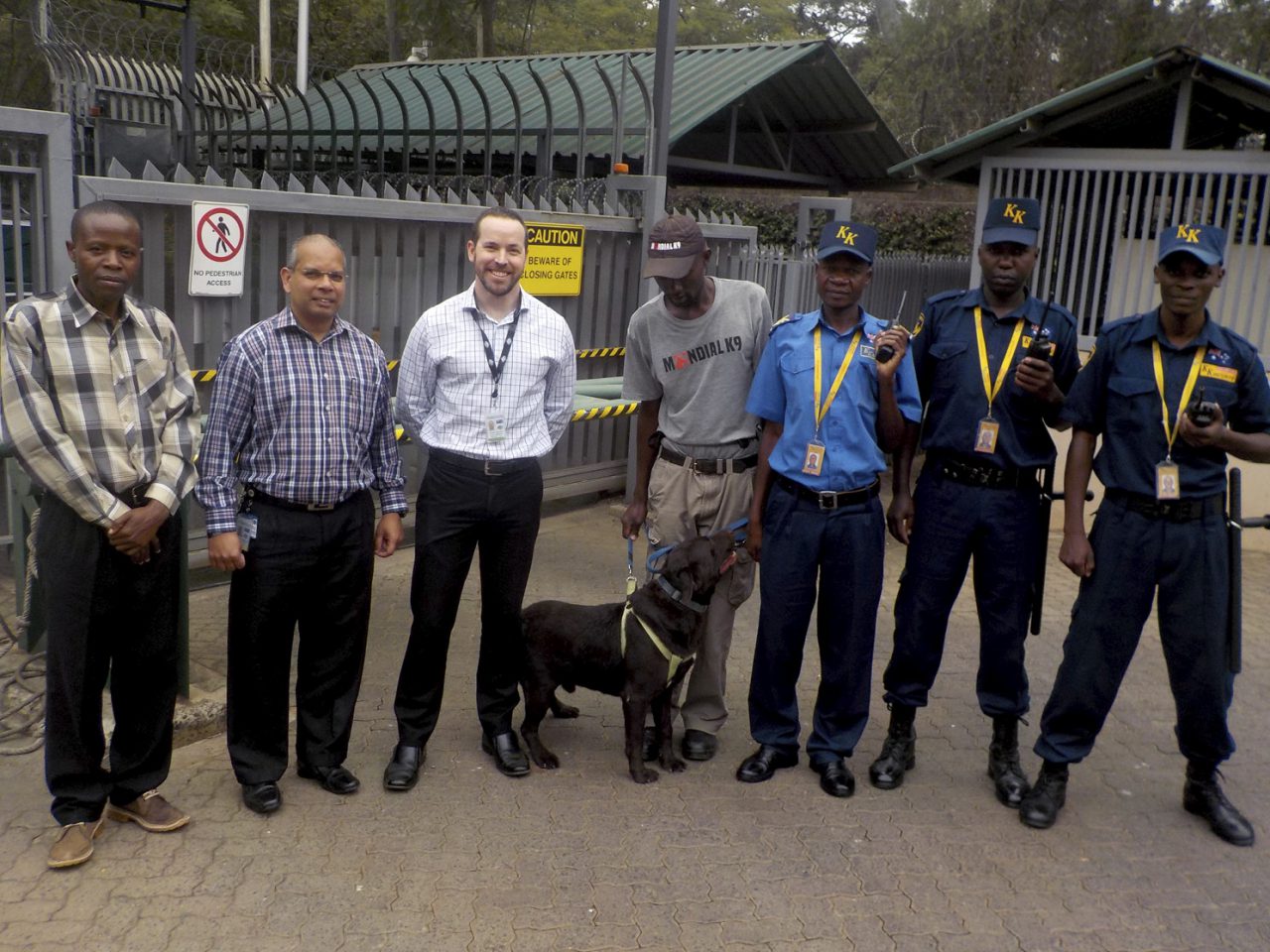 Regional Security Adviser Stuart Bulloch with Security Manager Brendan Fernandes, KK Security and Mondial K9 security staff, and explosives ordinance detection dog “Rango” at the Australian High Commission, Nairobi. [DFAT/Daniel Kamau]