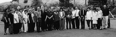 Group of people posing for photograph with mountains and trees in background