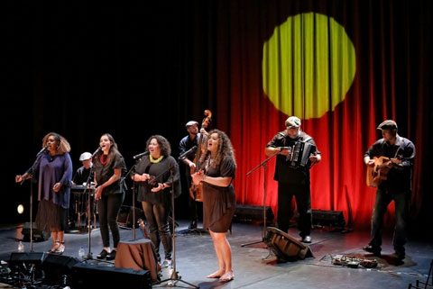 Mission Songs Project four female singers and three male band members performing on stage