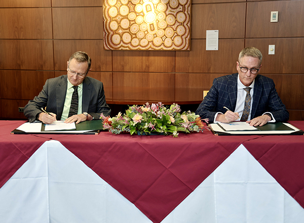Director General, Australian Safeguards and Non-Proliferation Office, Dr Geoffrey Shaw and Chief Executive Officer, Geoscience Australia, Dr James Johnson sitting at a table signing the MOC