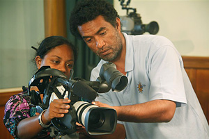 Photo of a man and a woman looking closely at the workings of a TV camera