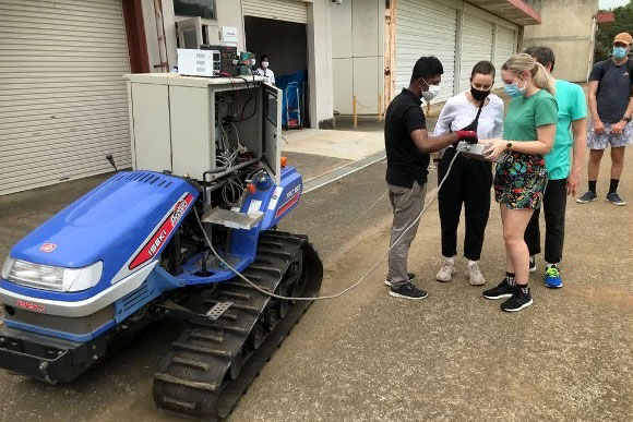 People standing around farm equipment