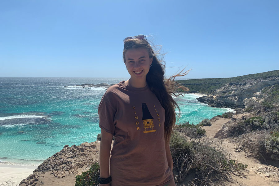Photo of Shannon Schulz standing of a cliff with ocean background.