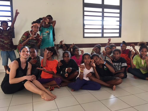Ella posing for a photo with seveal Kanaak youth
