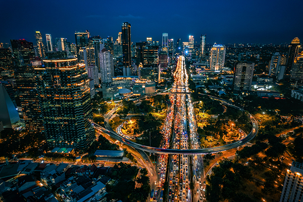 Aerial shot of Jakarta at night with bright lights and a circular motorway.