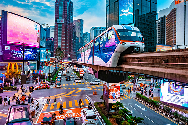 Aerial shot of a city intersection in Kuala Lumpur, with an elevated monorail above the street level