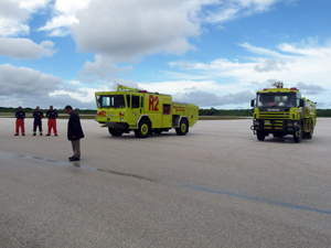 Niue International Airport fire rescue team standing in front of two fire trucks