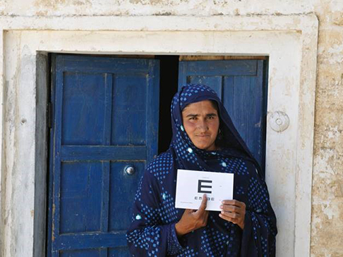 Shagufta in her village with her eye examination kit.
