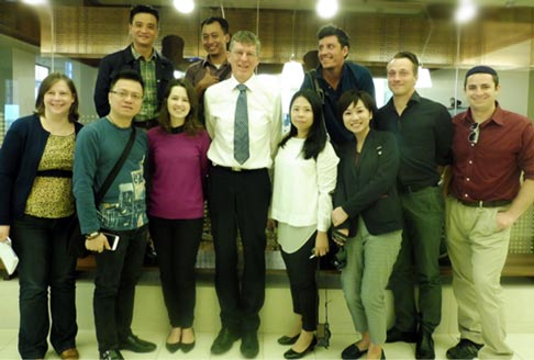 A group of international journalists stand around former Australian of the Year Professor Ian Frazer at the Translational Research Institute in Brisbane